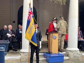 A person standing at a podium with a flag

AI-generated content may be incorrect.