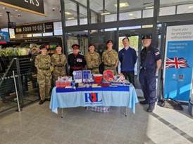 A group of people standing in front of a table

AI-generated content may be incorrect.